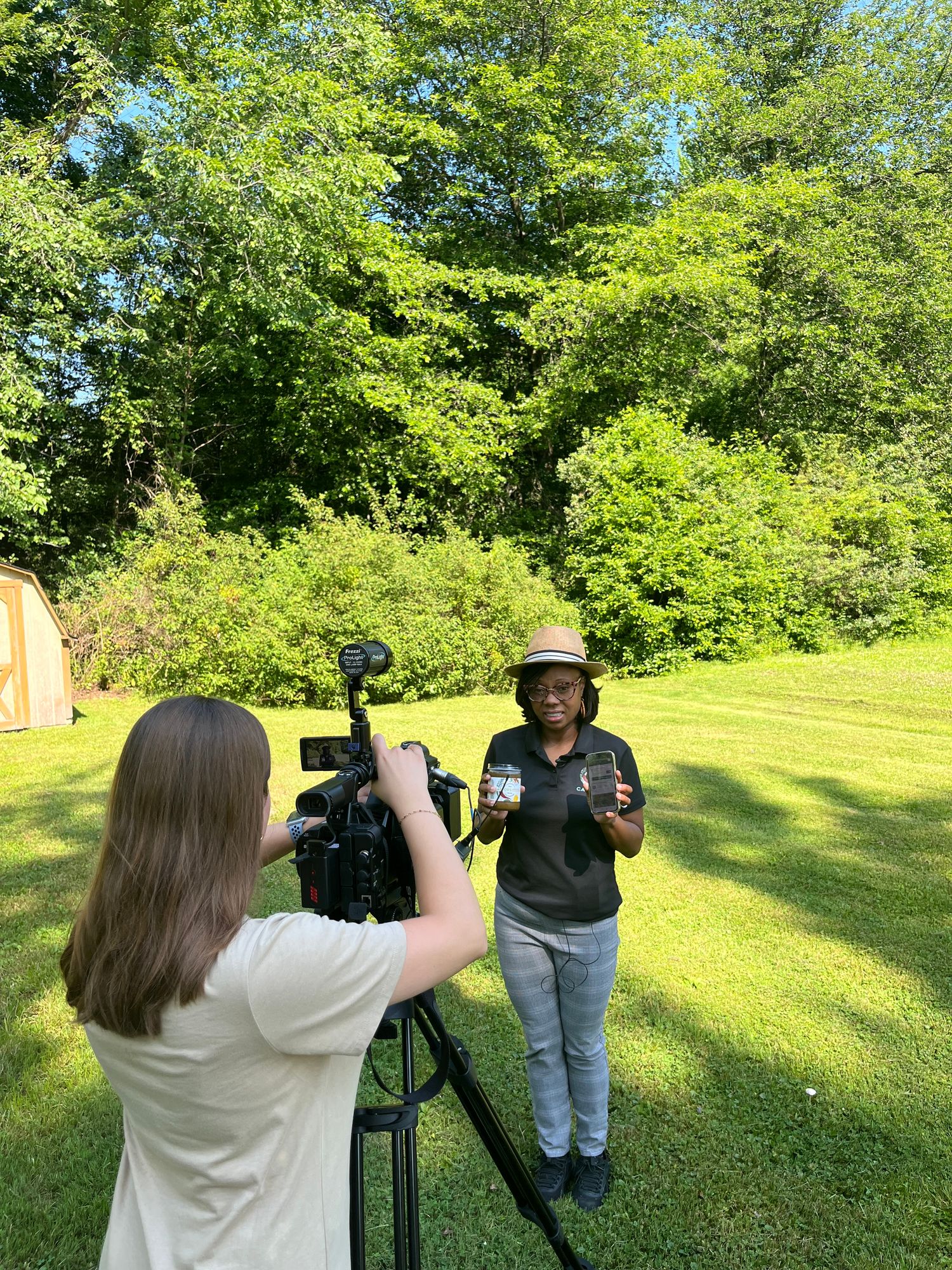 Behind the scenes filming a CASTORS product feature outdoors in a sunny green setting