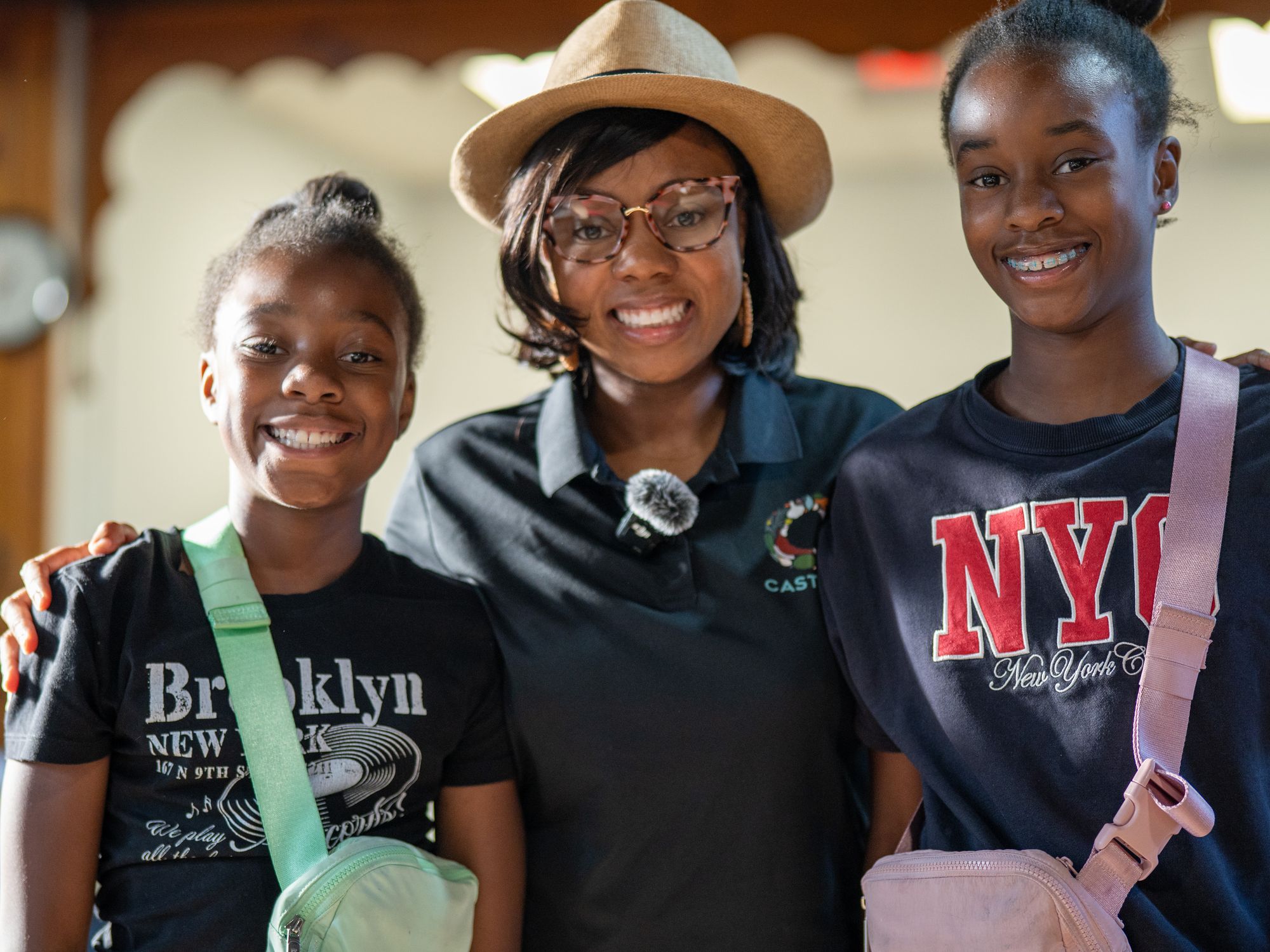 A CASTORS team member posing with two smiling children at a community event